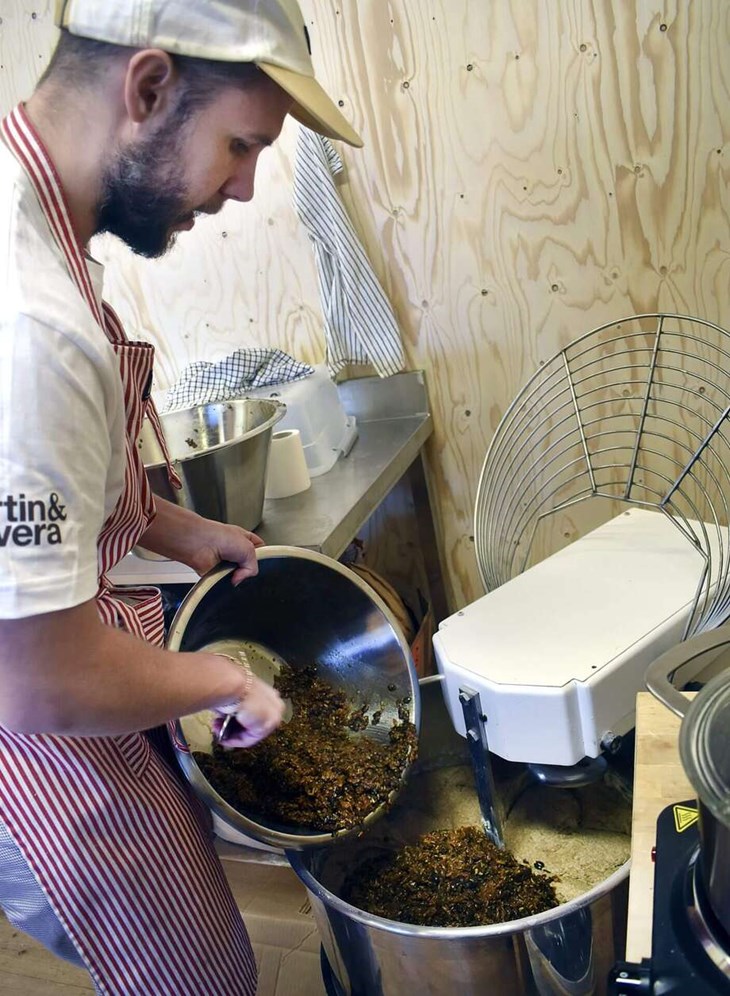 Johan Hjalmarsson rör ner en blandning i degen som ligger i degblandaren. "Den här blandningen består av rostade pumpafrön, solrosfrön och rågkross som har skållats och sedan blandats med brödsirap. Detta ska bli ett danskt rågbröd", säger han. Foto: Pär 