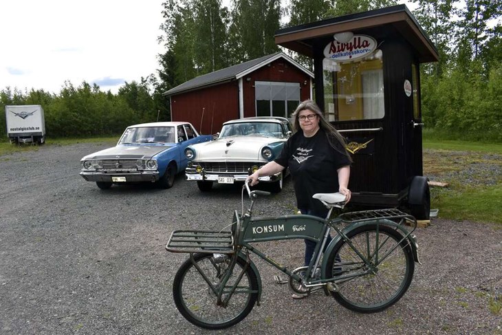 Anette Lindh med en gammal Konsumcykel. I bakgrunden, längst till vänster, skymtar det släp som används som scen för musikerna under Nostalgidagarna. Foto: Pär Sönnert