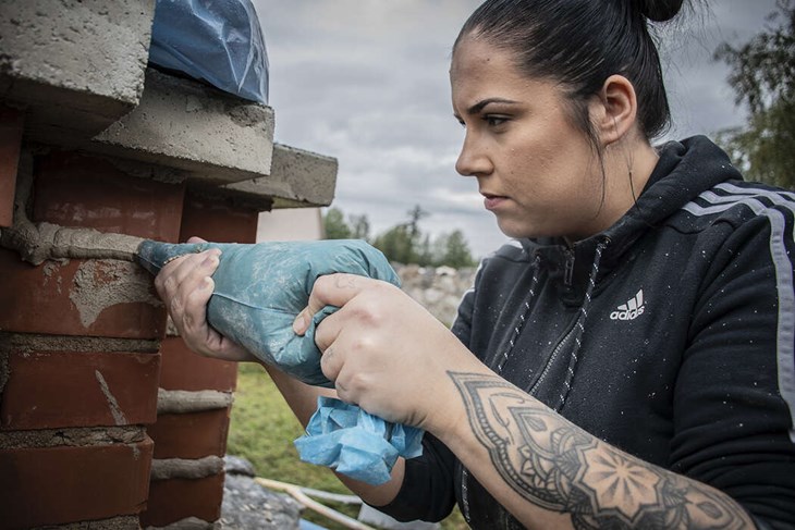 My Johansson spritsar fogen mellan tegelstenarna. Foto: Christian Larsen