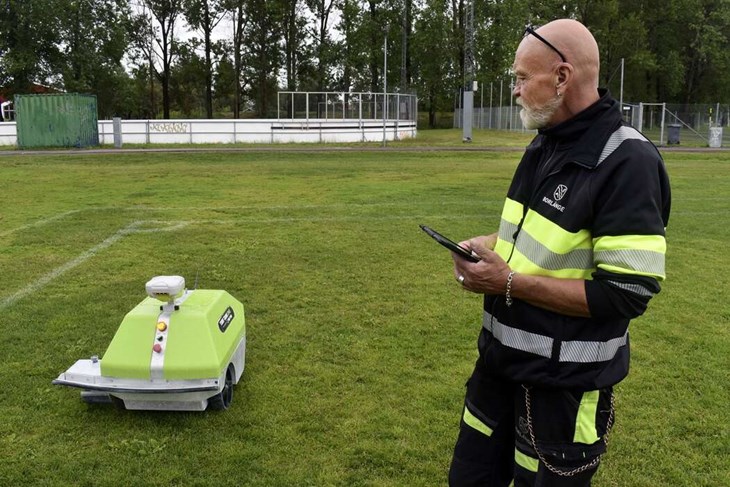 Magnus Lindberg är gruppledare för vaktmästarna inom ”Idrottsenheten norra” inom Borlänge kommun. Här demonstrerar han hur, den ännu namnlösa, linjeringsroboten rör sig. Förutom Sportfältet jobbar roboten även på andra anläggningar i kommunen. "Bland annat vid Gyllevallen, Tunets IP och Idunvallen. Totalt ligger 61 planer inlagda här i ´paddan´. Den navigerar via satelliter och vi måste ha med ankringspunkter för att ställa in den på plats, sedan är det bara för den att börja jobba", förklarar Magnus. Foto: Pär Sönnert