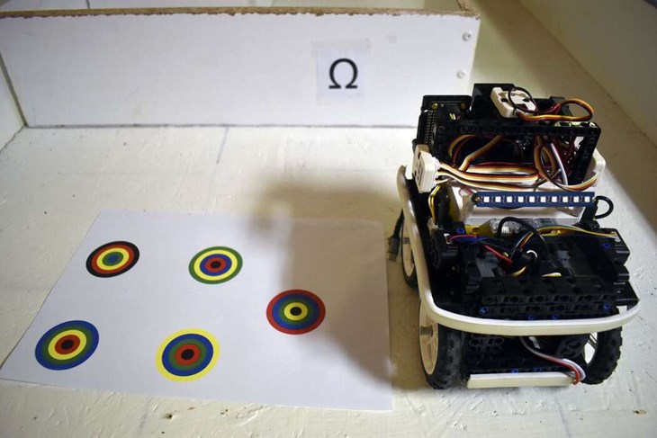 Kusinernas robot har de döpt till "Hubert". Här visar de upp hur det kan se ut på tävlingarna, där roboten ska åka runt i en labyrint och lösa olika uppgifter, som exempelvis att hitta rätt bland de färgglada cirklarna som ses till vänster. Foto: Pär Sönnert