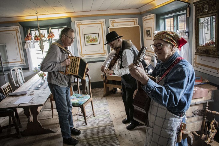 I Gästabudssalen på Hedemora Gammelgård berättade Lena Borgs om hur festerna var förr och bjöd samtidigt på musik med Bosse Eriksson på durspel och Per Jakobsson på fiol. Foto: Christian Larsen