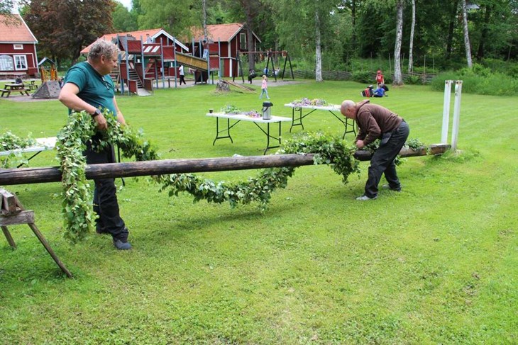 Per och Micke virade den lövade girlangen runt midsommarstången.