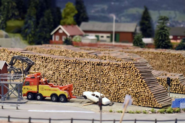 En bärgningsbil bärgar en vit bil i närheten av ett virkesupplag. Detaljerna är många i landskapet. Foto: Pär Sönnert