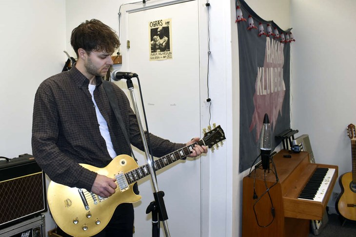 Även om Joel Burman trivs bra i replokalen och studion så vill han även åt nerven och känslan av att spela live. Här poserar han med gitarren i replokalen vid Fornby folkhögskola. Foto: Pär Sönnert