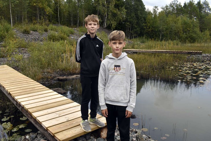 Kompisarna Rasmus Karlsson och Edvin Grånäs har, tillsammans med Rasmus bror Theo, byggt tretton broar vid Gråbergsdammen. Den 12 september invigs spelplatsen med föreställningen ”Brud i Sommarnatt". Foto: Pär Sönnert