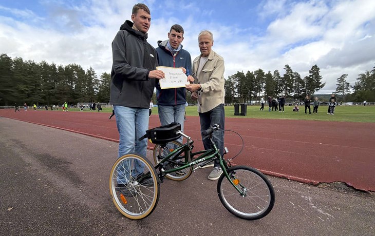Daniel och Adam Hansson delar ut 25 000 kronor till Ola Brossberg, ordförande i Parasport Dalarna, så att de kunde köpa en racerunner, som syns på bilden. Foto. Parasport Dalarna